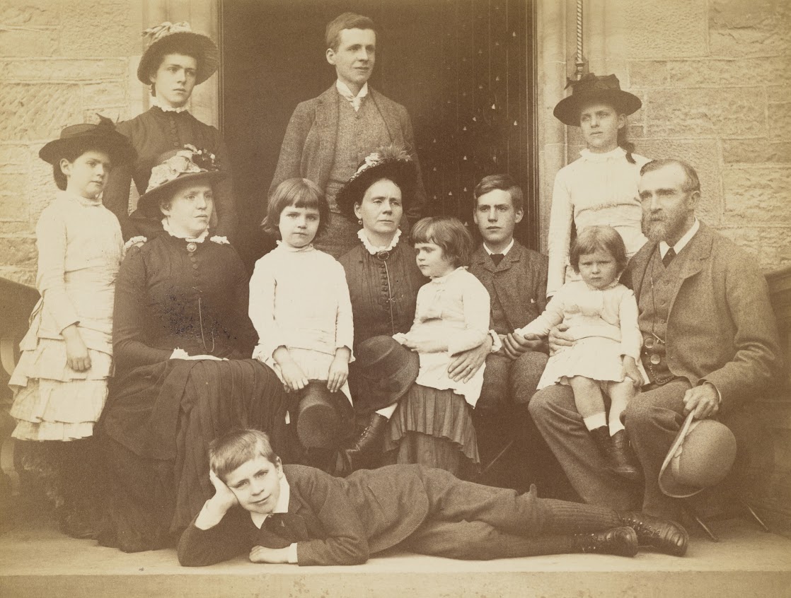 A photo of the Findlay family variously standing and sitting in an open doorway.