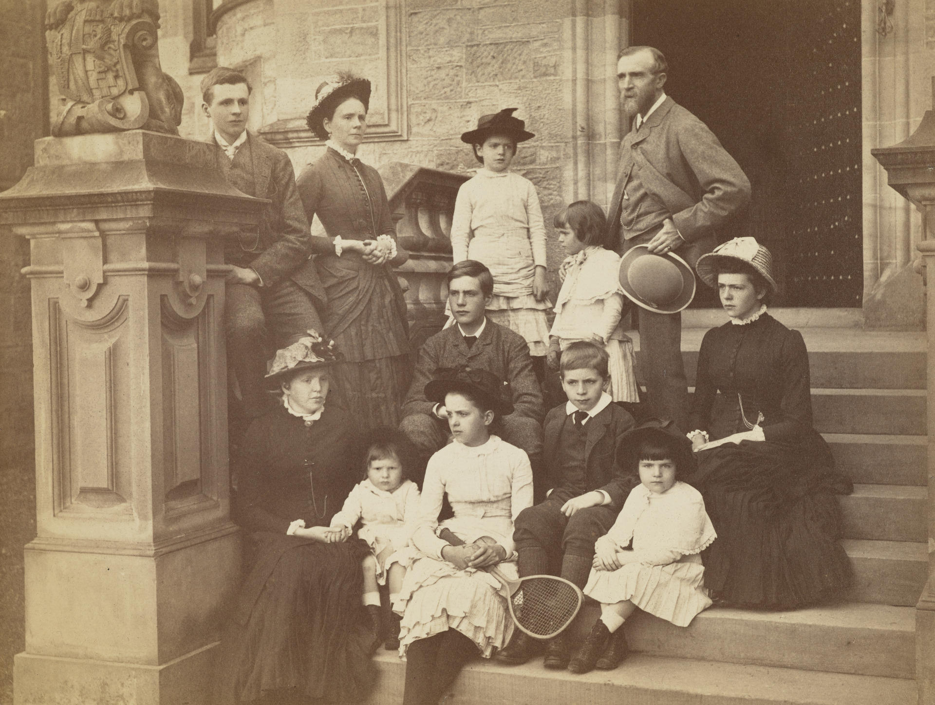 A photo of the Findlay family standing and sitting on stone steps in front of an open doorway.